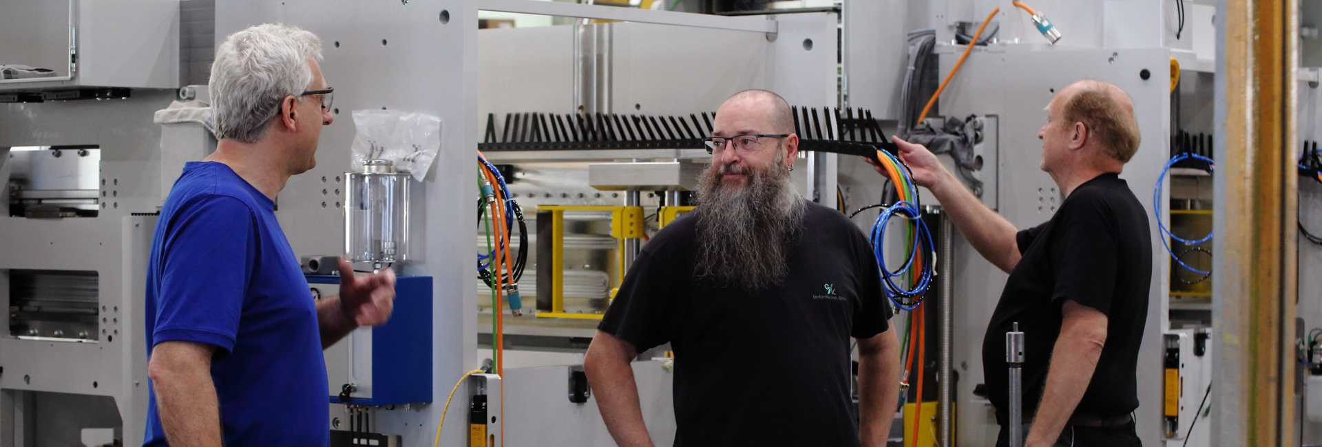 Mitarbeiter an einer Maschine im Gespäch